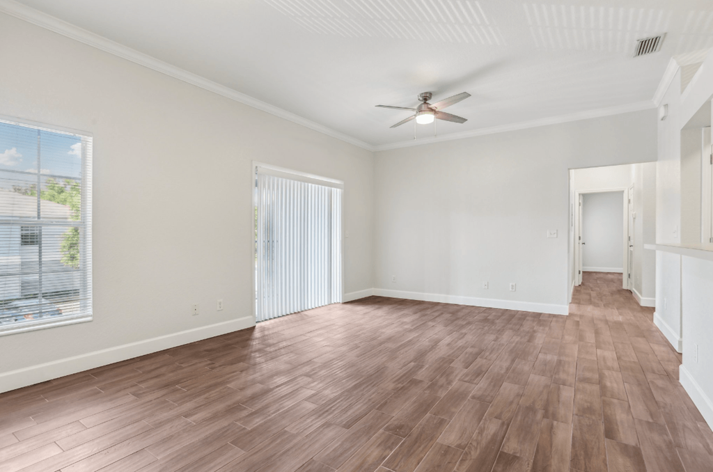 A room with wooden flooring and a ceiling fan.